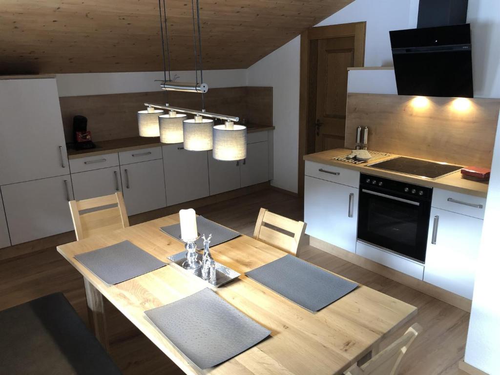 cocina con mesa de madera y electrodomésticos blancos en Hacklstoana, en Alpbach