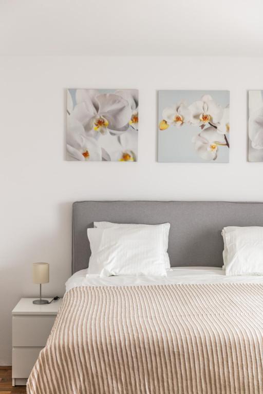 a bedroom with a bed with three pictures on the wall at KRACHER Familienapartment mit Nationalparkblick in Illmitz