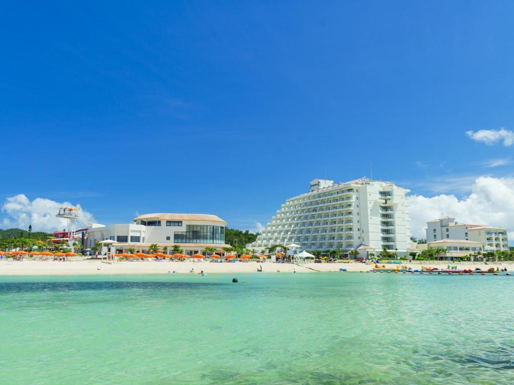 a view of a beach with buildings in the background at Sheraton Okinawa Sunmarina Resort in Onna