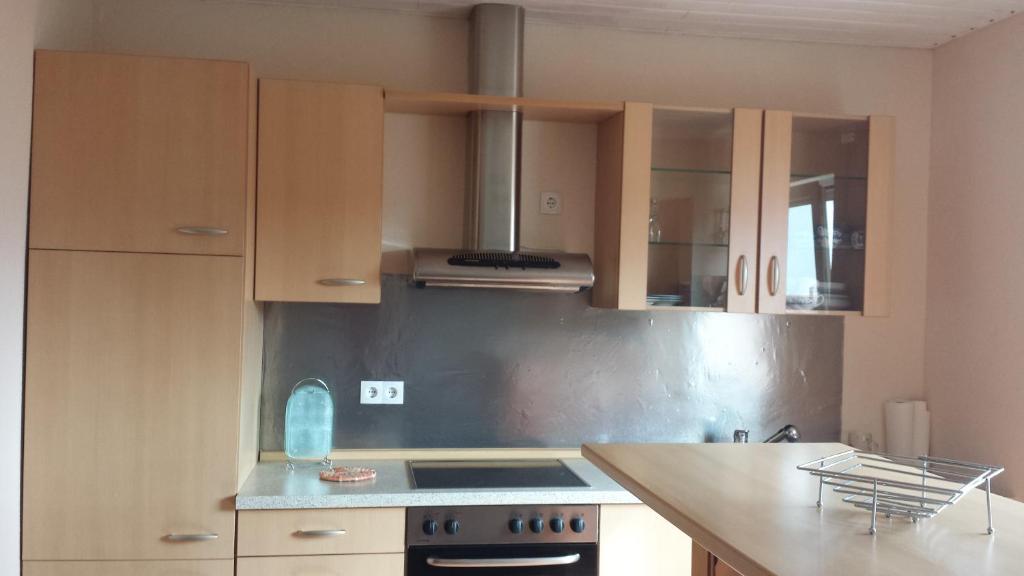 a kitchen with wooden cabinets and a stove top oven at Pension Rosenblick in Mörlenbach