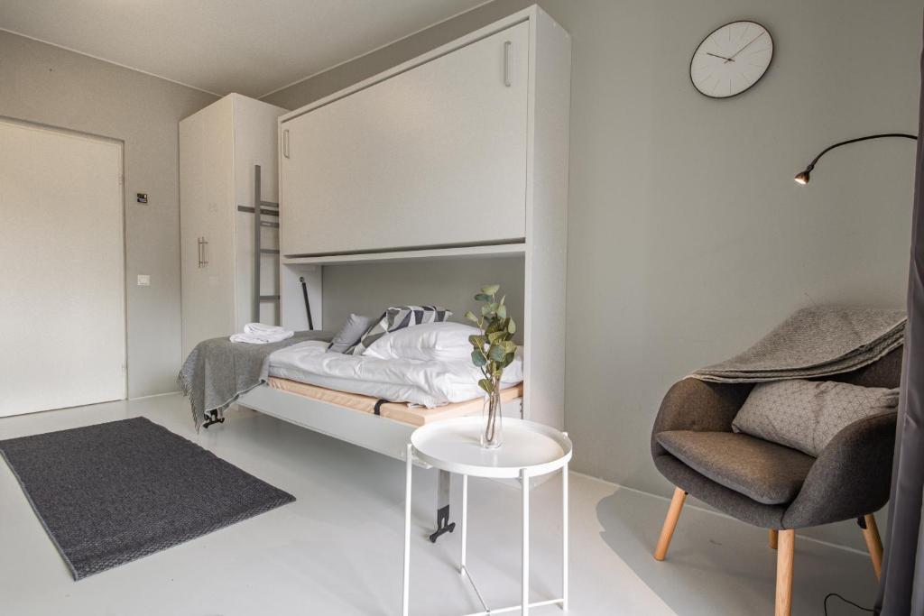 a bedroom with a bed and a table and a chair at Spot Apartments Rajakylä in Vantaa