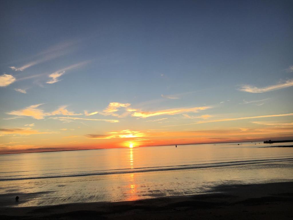 einen Sonnenuntergang am Strand mit Sonnenuntergang in der Unterkunft La Maison s'apelle le P'tit Nid in Granville