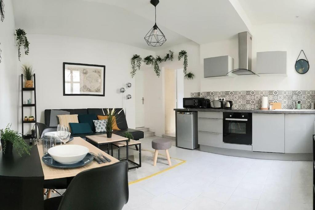 a kitchen and a living room with a table at Le Solençon de 1 à 4 pers - Hypercentre in Cognac