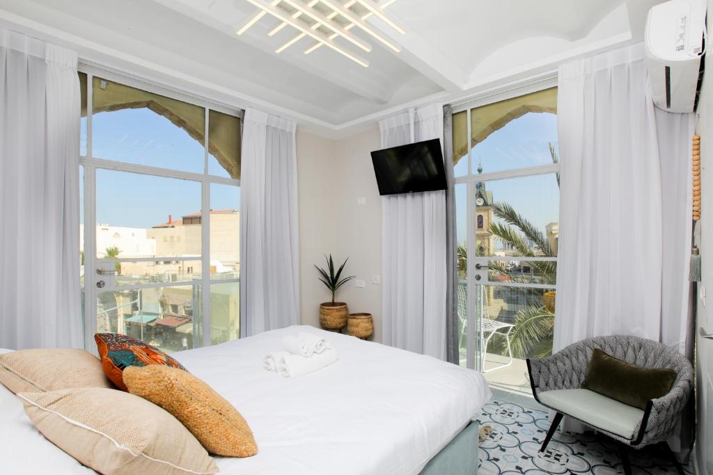 ein Schlafzimmer mit einem Bett und einem großen Fenster in der Unterkunft Jaffa Garden boutique in Tel Aviv