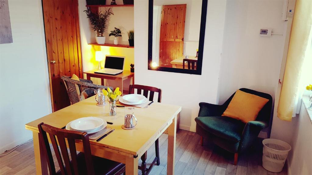 a dining room with a table and chairs and a laptop at Stylish and homely space with considered work area in Norwich