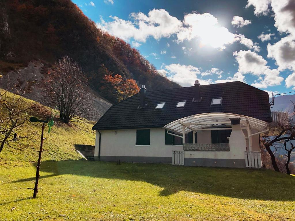 Biały dom z dachem na trawniku w obiekcie Apartment Pri Leju w mieście Srpenica