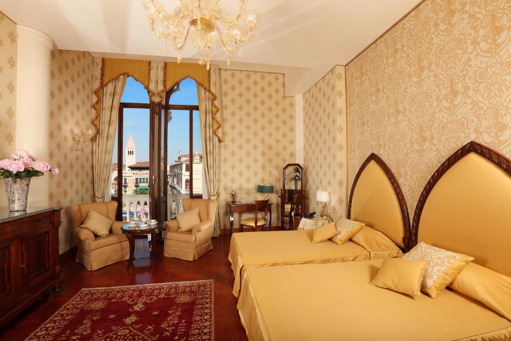 a bedroom with two beds and a chandelier at Hotel Palazzo Stern in Venice