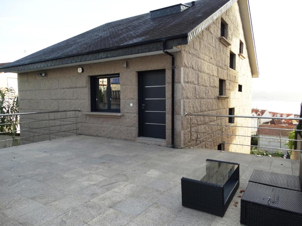 un edificio con una puerta negra y un patio en Panxón, en Nigrán