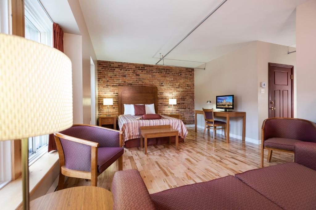 une chambre d'hôtel avec un lit, une table et des chaises dans l'établissement Hotel Quartier des Spectacles, à Montréal