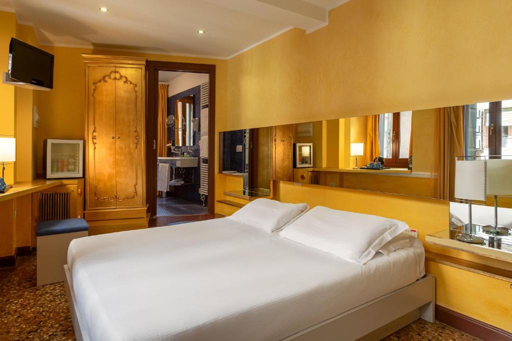 a bedroom with a large white bed and yellow walls at Sogno di Giulietta e Romeo in Venice