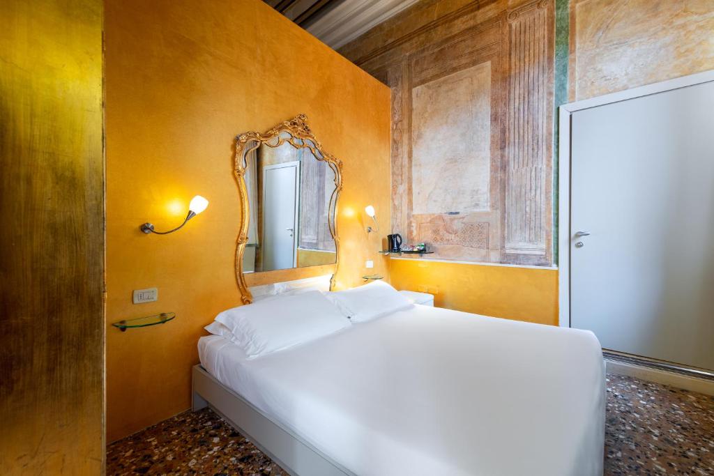 a bedroom with a white bed and a mirror at Sogno di Giulietta e Romeo in Venice
