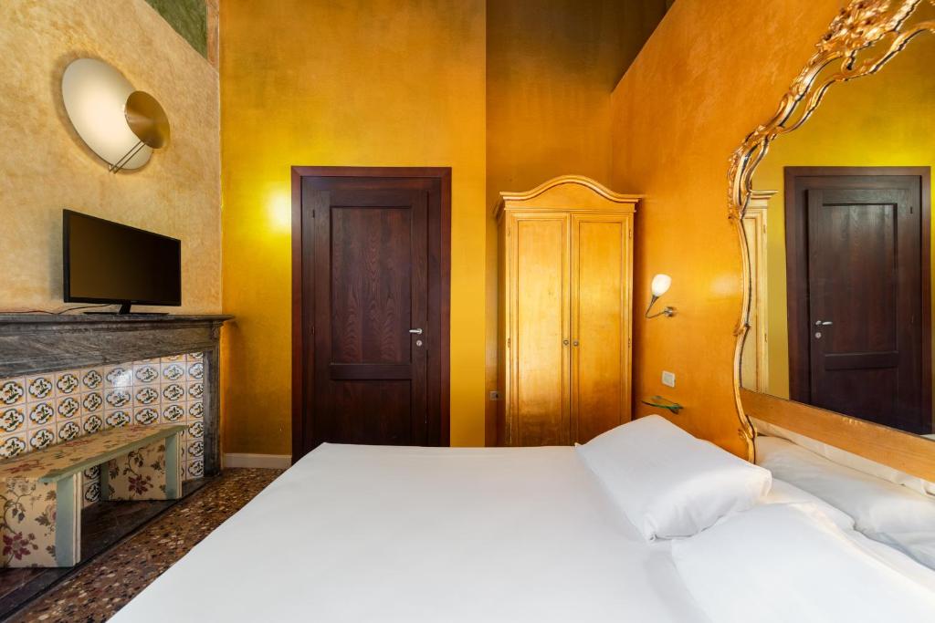 a bedroom with a white bed and a tv at Sogno di Giulietta e Romeo in Venice