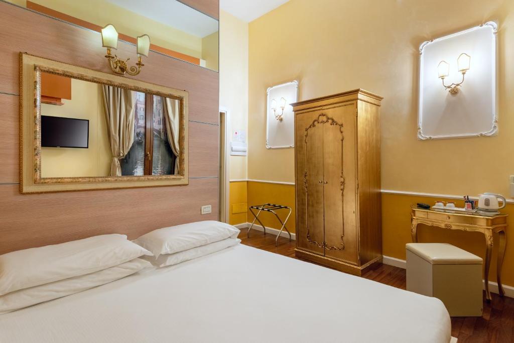 a bedroom with a white bed and a mirror at Sogno di Giulietta e Romeo in Venice