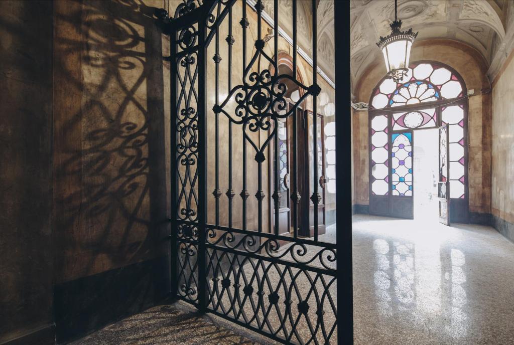 an iron gate in a building with a window at Gregorini Bingham Art Luxury Suites in Bologna