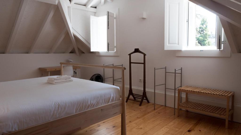 ein Schlafzimmer mit einem weißen Bett und einer Treppe in der Unterkunft APOSENTUS - Architect and design apartment in Porto