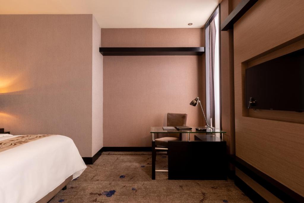 Postel nebo postele na pokoji v ubytování New World Suites