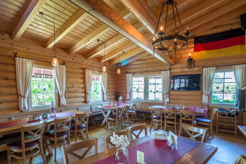 a restaurant with tables and chairs in a room with wooden walls at Carolinger Hüttendorf in Weyer