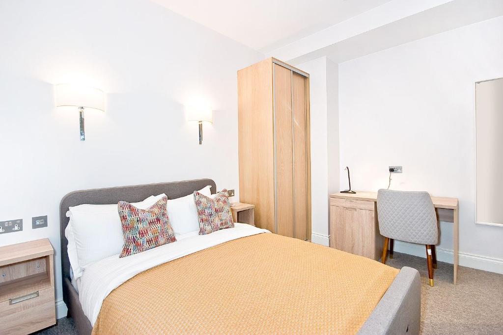 a bedroom with a bed and a desk and a chair at Eldon Chambers Pod 2 by City Living London in London