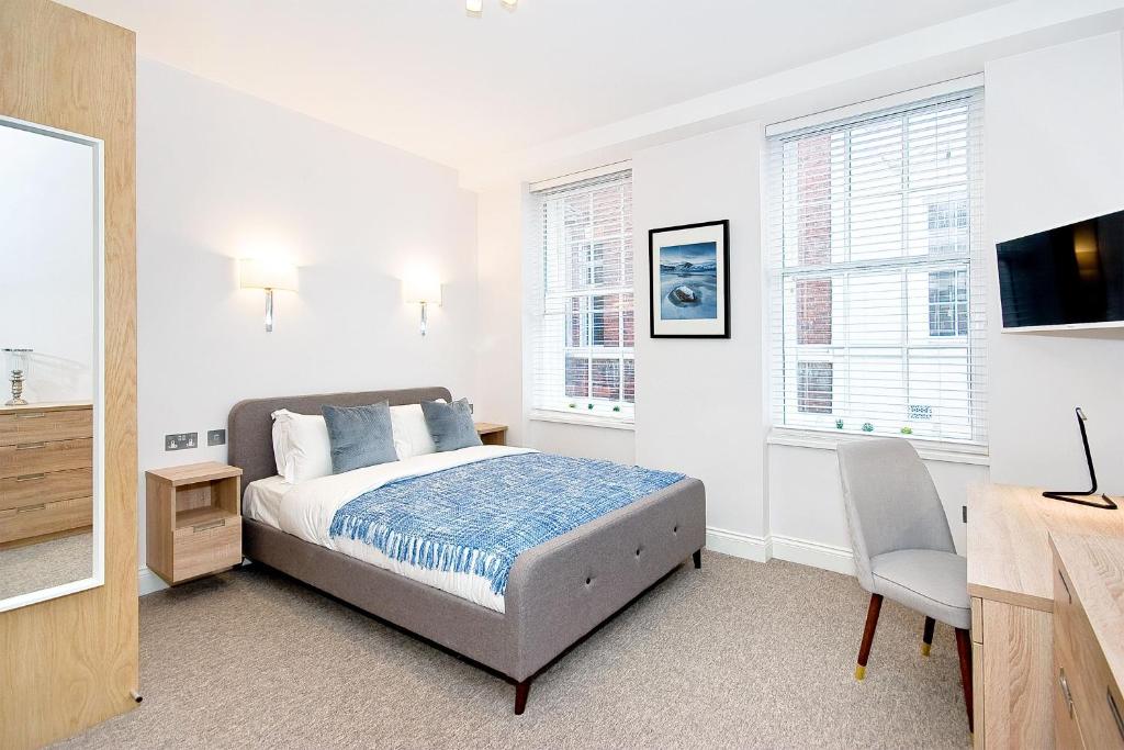 1 dormitorio con 1 cama, TV y ventanas en Eldon Chambers Pod 1 by City Living London en Londres