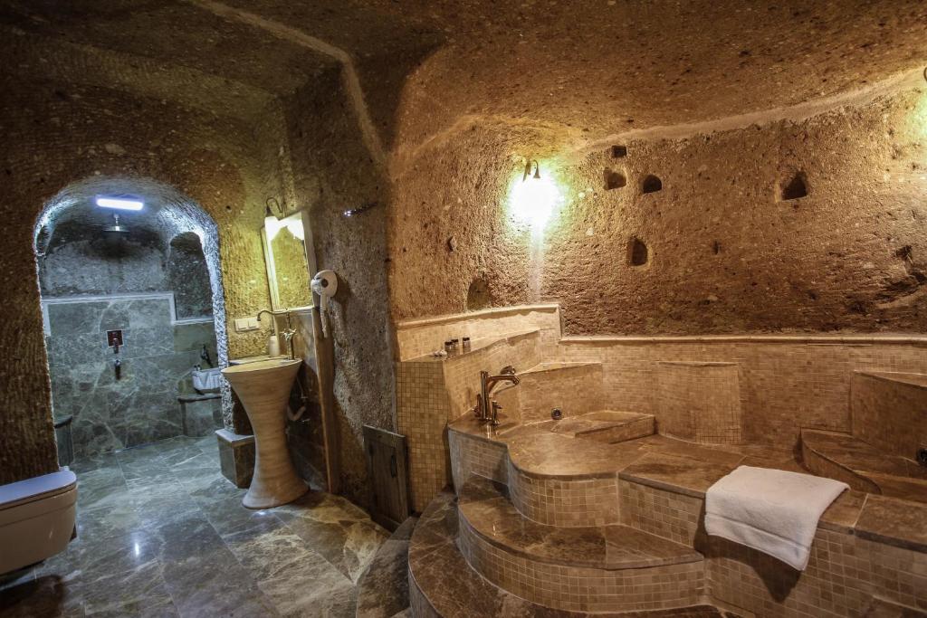 Baño de piedra con bañera y lavamanos en Heaven Cave House - Razziya Evi, en Ürgüp