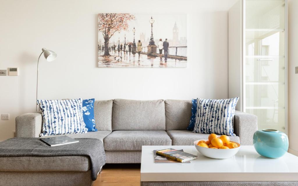 a living room with a couch and a bowl of oranges on a coffee table at Fabulous 3 Bed 2 Bath near Victoria Station in London