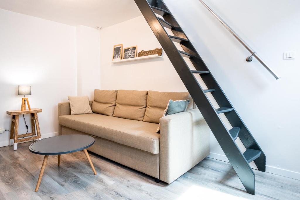 un salon avec un canapé et un escalier dans l'établissement Little Suite Paulette, à Lille
