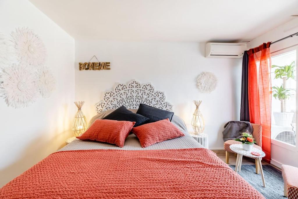a bedroom with a red bed with red pillows at Studio centre ville avec parking in Sanary-sur-Mer