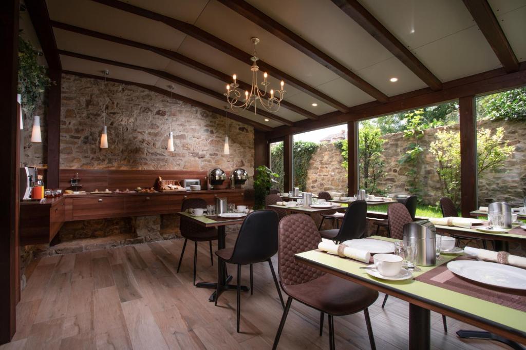 a restaurant with tables and chairs and a stone wall at Hotel Anna in Beroun
