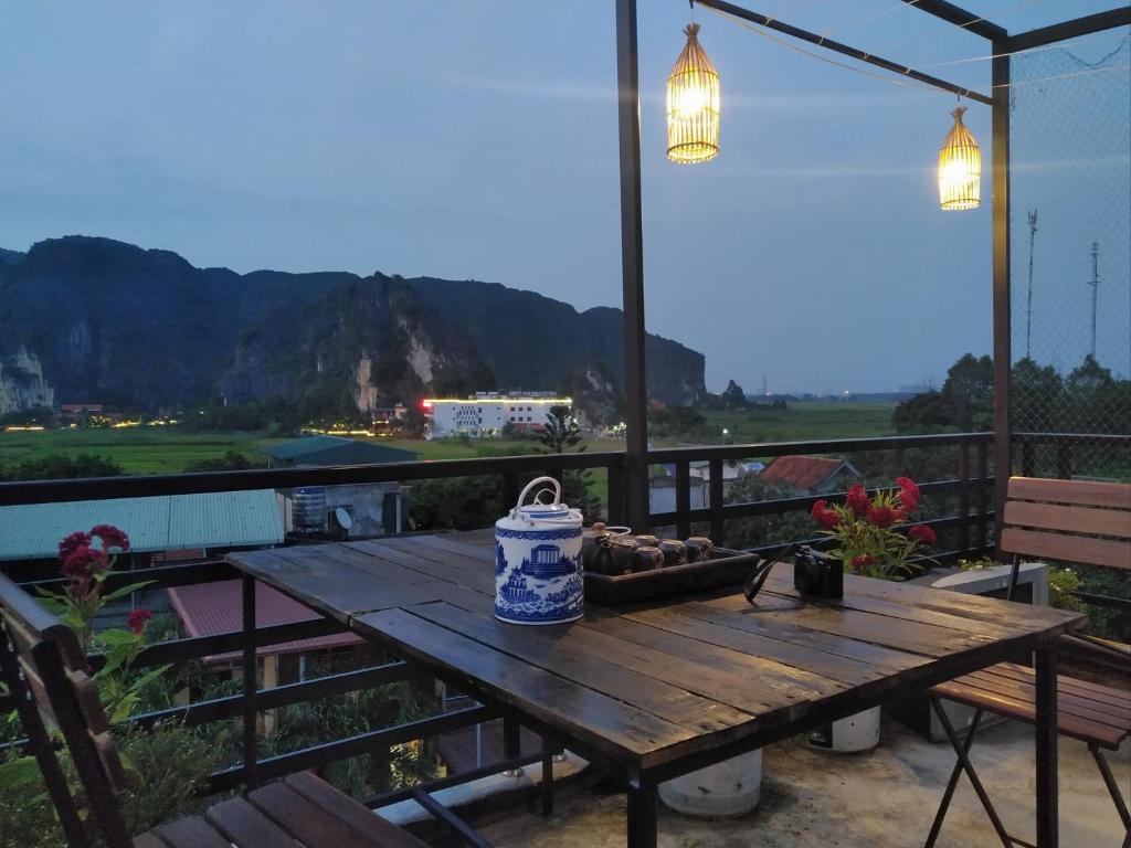 einen Holztisch mit einem Eimer auf dem Balkon in der Unterkunft Tam Coc Sweet Home in Ninh Bình