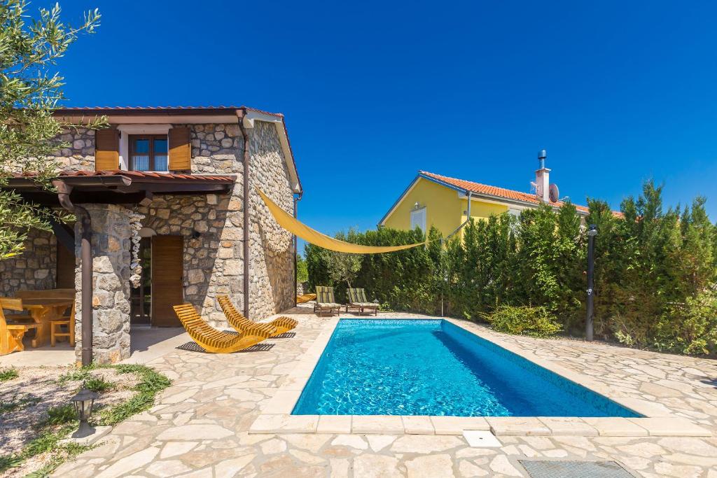 Dobrinj的住宿－藍色常春藤度假屋，一座房子后院的游泳池