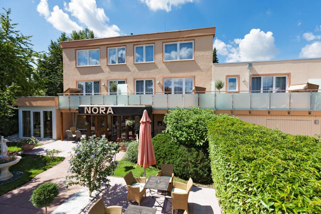 a hotel with a patio with an umbrella at Hotel Nora in Bad Krozingen