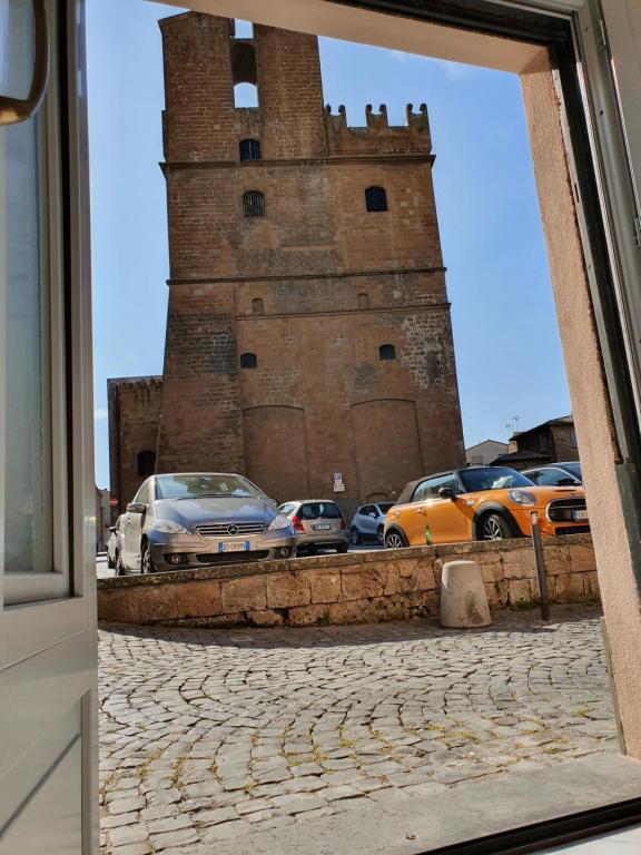 un reflejo de coches estacionados frente a una torre en Al Pozzo Bianco, en Orvieto