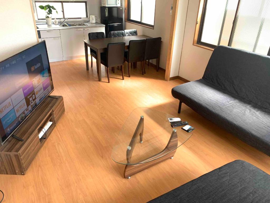 a living room with a couch and a table at ガナダン中央駅 2f 無料駐車場 in Kagoshima