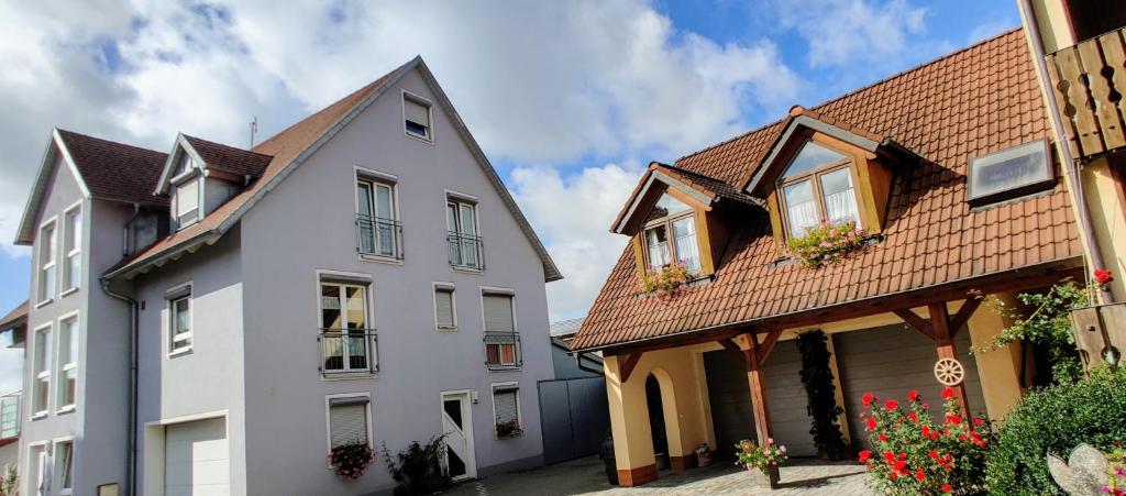 une maison blanche avec un toit marron à côté de deux bâtiments dans l'établissement Apartment / Ferienwohnungen Christ, à Rothenburg ob der Tauber