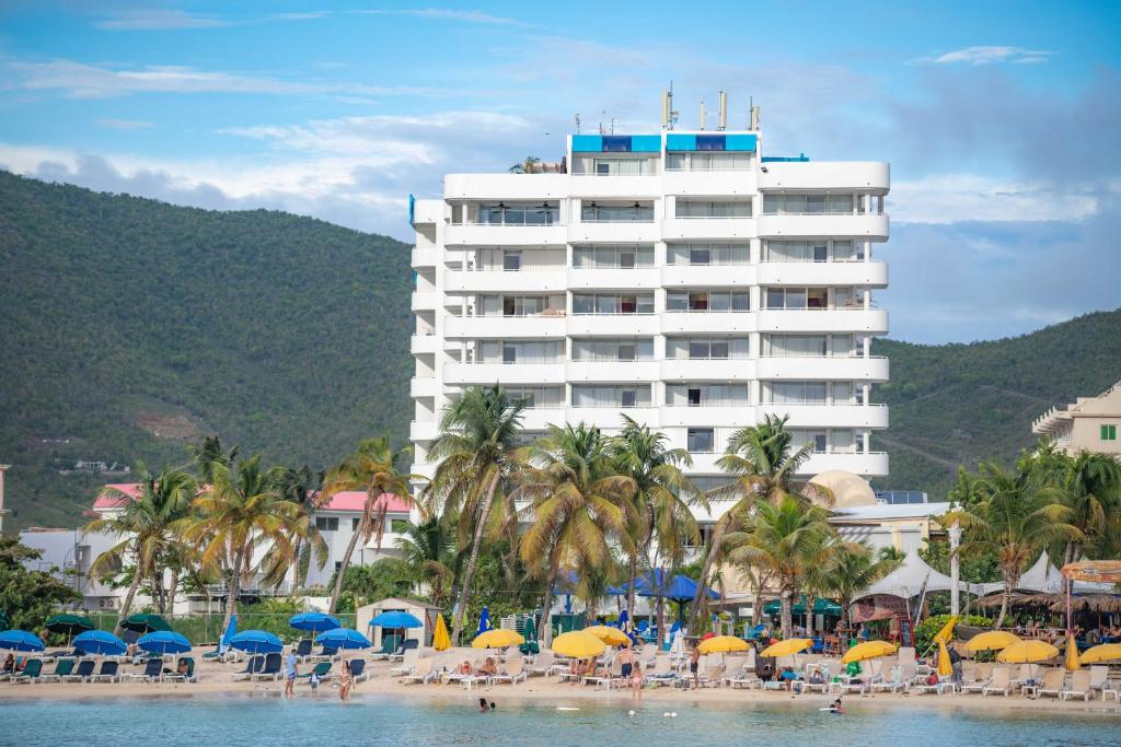 um hotel na praia com cadeiras e guarda-sóis em Atrium Beach Resort and Spa St Maarten a Ramada by Wyndham em Simpson Bay