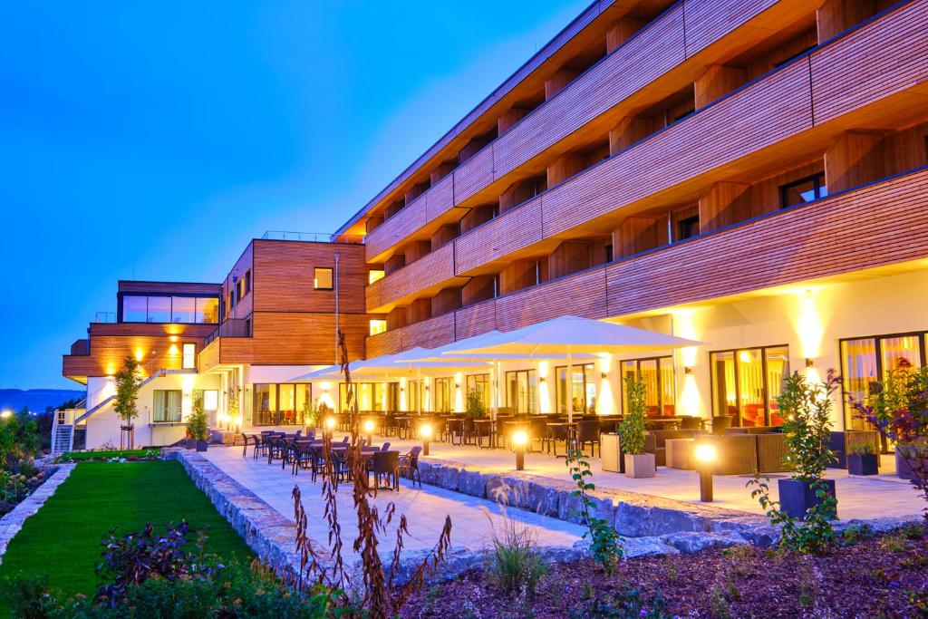 un gran edificio con patio por la noche en Sonnenhotel Weingut Römmert en Volkach