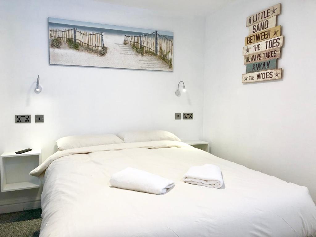 Un dormitorio con una cama blanca con dos toallas encima. en Empress Select Holiday Flats, en Blackpool