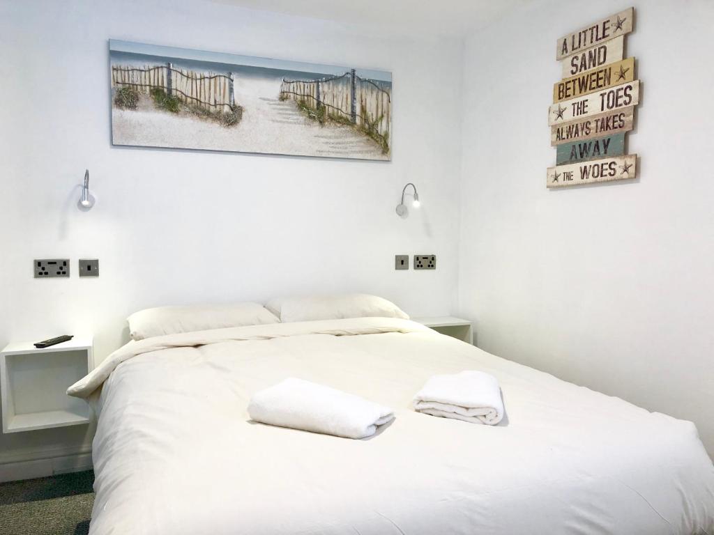 a bedroom with a white bed with two towels on it at Empress Select Holiday Flats in Blackpool