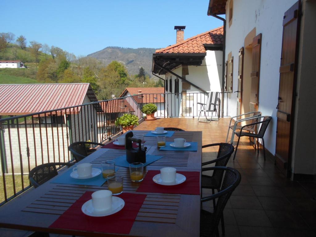 una mesa con platos de comida en el balcón en Casa Rural Juankonogoia, en Urrotz