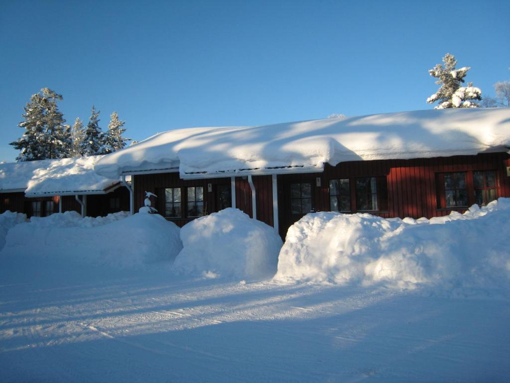 a snow covered house with a lot of snow around it at Saariselän Marjamajat Apartment Sopuli in Saariselka