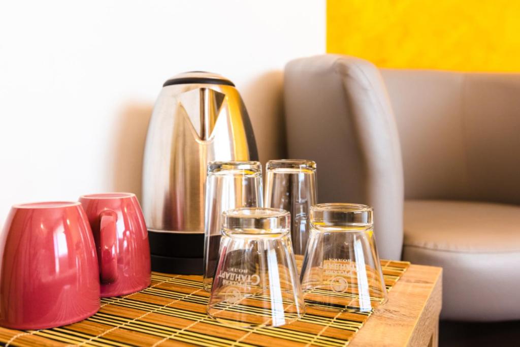 a table with three glass bottles and a coffee pot at Guest House Theona in Obzor