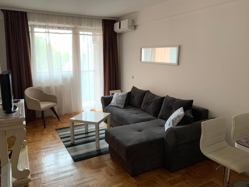 sala de estar con sofá y mesa en Trident Apartments en Niš