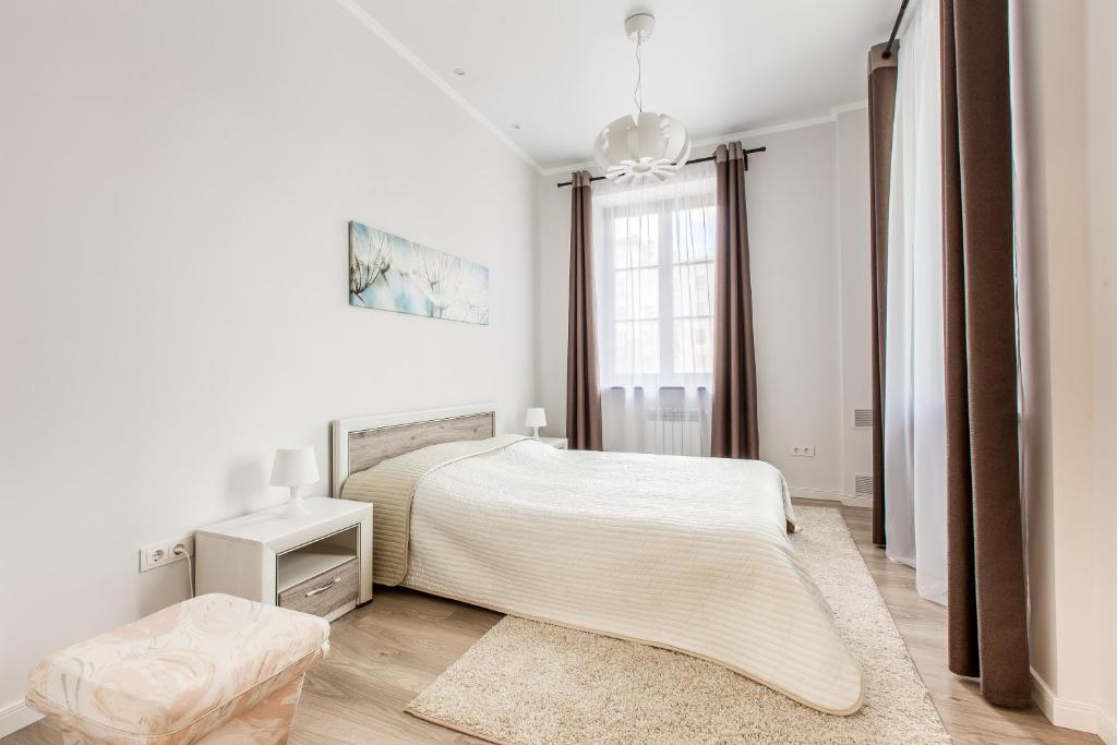 a white bedroom with a bed and a window at SutkiMinsk Economy in Minsk