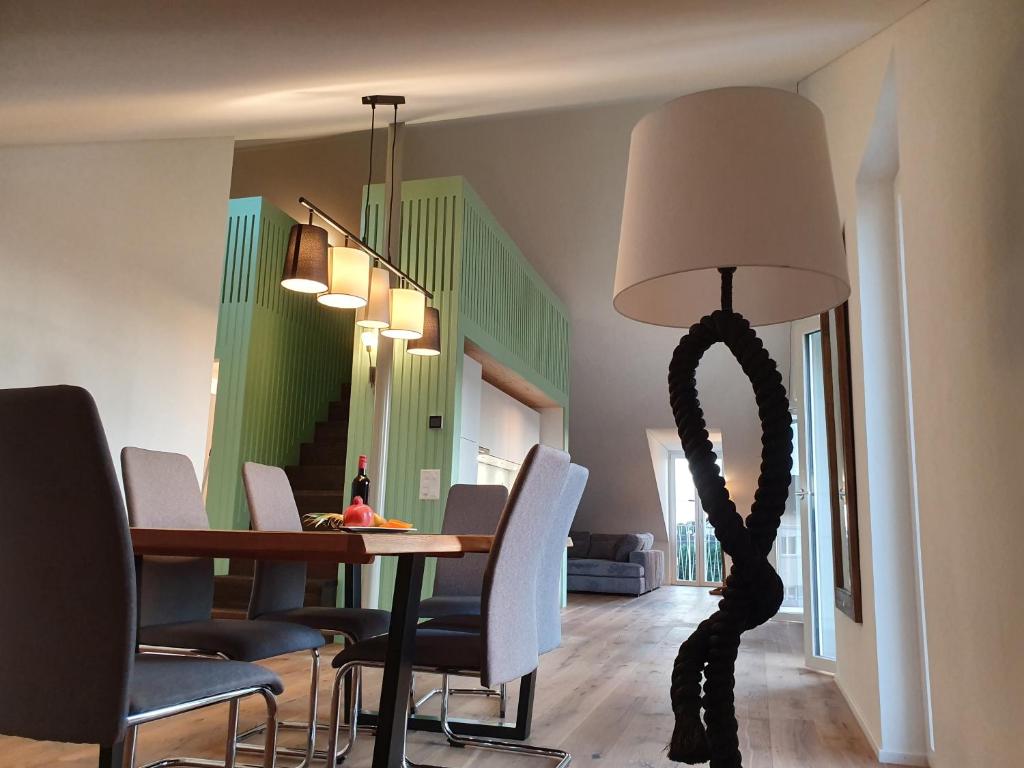 a dining room with a table and a floor lamp at Wohnstation President Suite in Subingen