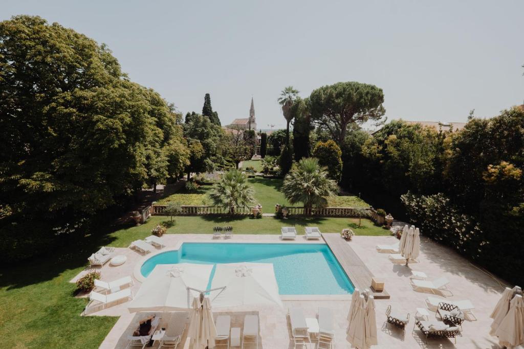 - une vue aérienne sur une piscine bordée de chaises et d'arbres dans l'établissement La Villa Guy & Spa - Teritoria, à Béziers
