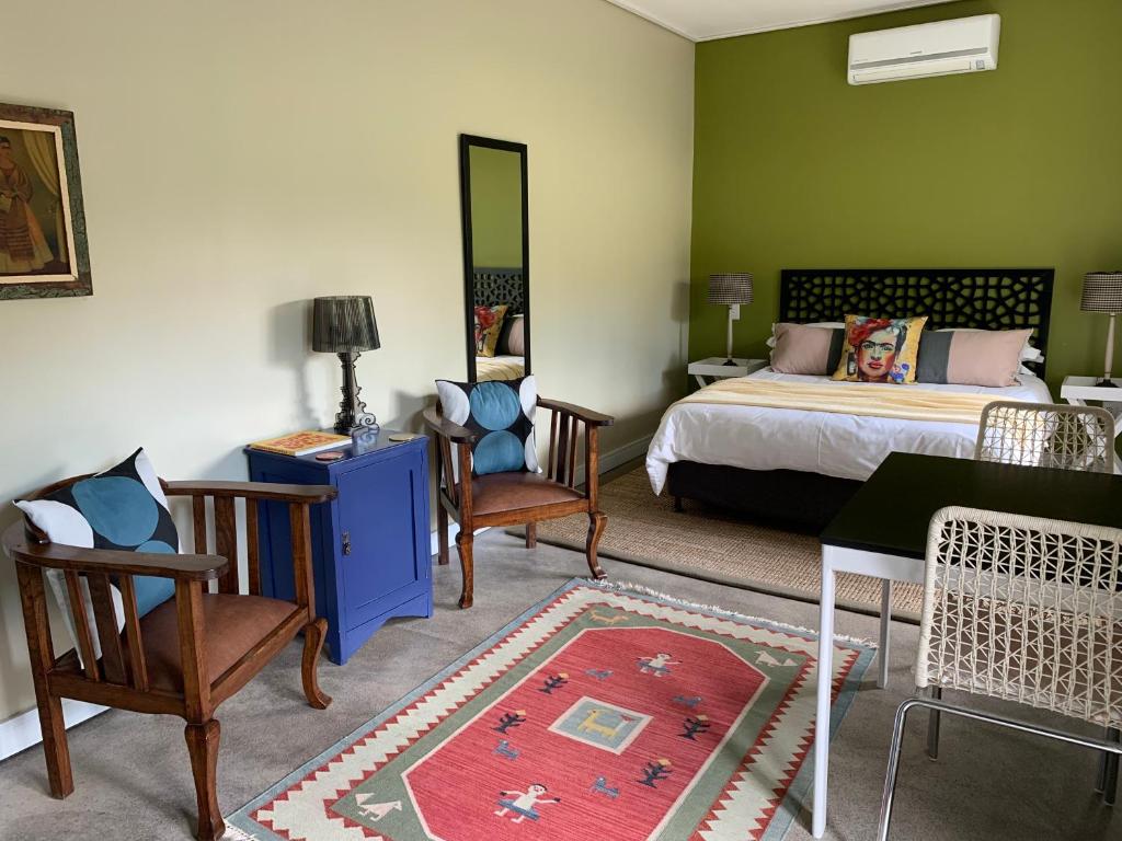 a bedroom with a bed and a table and chairs at Frida’s Place - Quiet in Stellenbosch Central in Stellenbosch