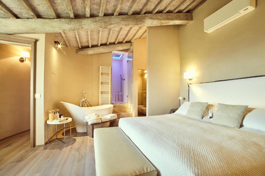 1 dormitorio con 1 cama grande y bañera en Il Torrino - Deb'S Monticchiello, en Pienza