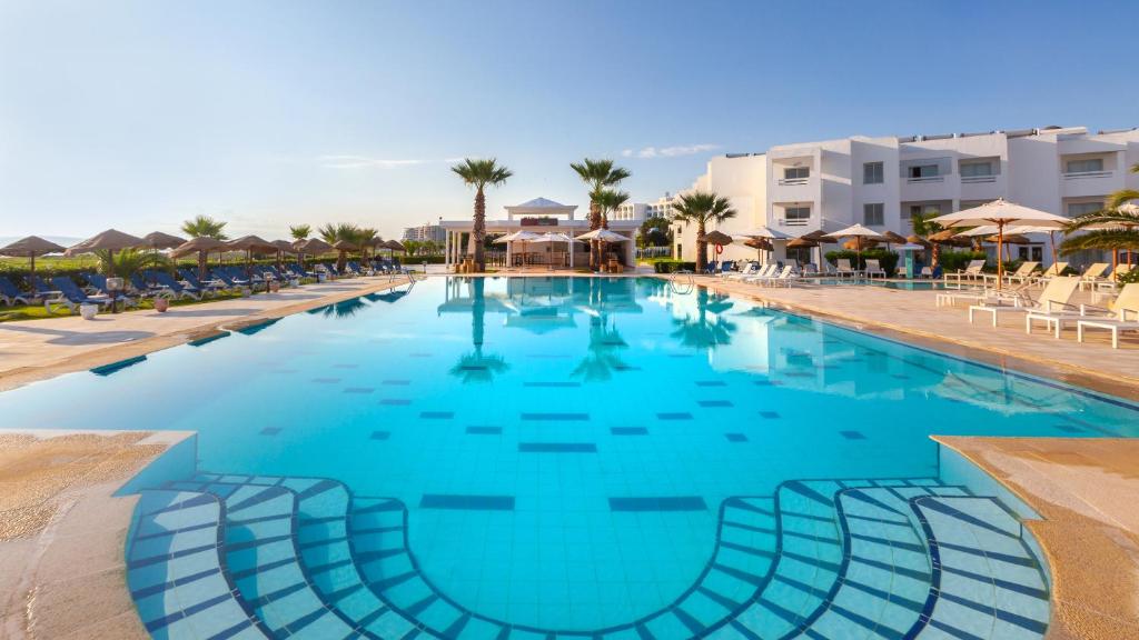 a large swimming pool with blue water in a resort at Hotel Nour Congress & Resort in Bizerte