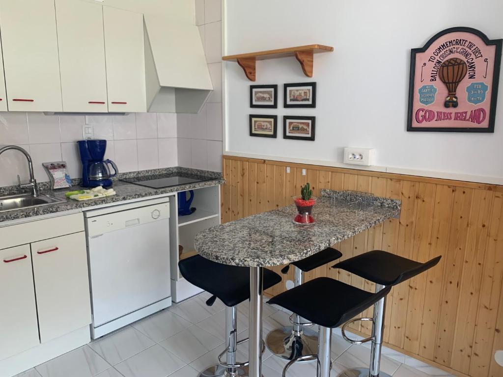 a kitchen with white cabinets and a table with chairs at FRONT563 CONFORT in Pas de la Casa