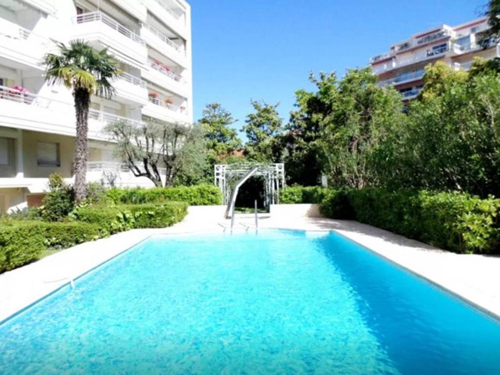 a swimming pool in front of a building at Lux Studio our swimming pool and garden in Cannes